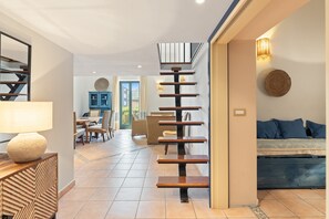 Un interior moderno con una escalera, una zona de comedor y un sofá.