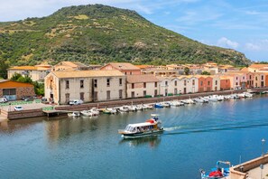 A coastal town with a marina, boats, and buildings along the waterfront.
