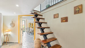A staircase with wooden steps and metal railings, leading to a balcony.