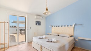 A bedroom with a bed, a ceiling light, a window, and an air conditioning unit.
