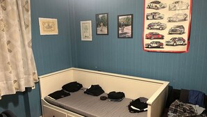 Une pièce avec un lit, un mur orné de tableaux encadrés et une fenêtre avec des rideaux.