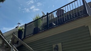 Een woongebouw met een houten trap die naar een balkon leidt.