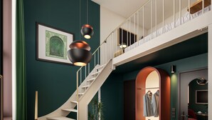 Ein modernes Interieur mit Treppe, Pendelleuchten und einem gerahmten Bild an der Wand.