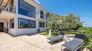 A two-story house with a balcony, outdoor seating, and a view of the surrounding landscape. - Villa 'Anna Messina' with sea view, Wi-Fi and air conditioning (Carini)
