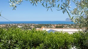 A coastal town with olive trees, a view of the sea, and a building with solar panels. - Villa 'Anna Messina' with sea view, Wi-Fi and air conditioning (Carini)