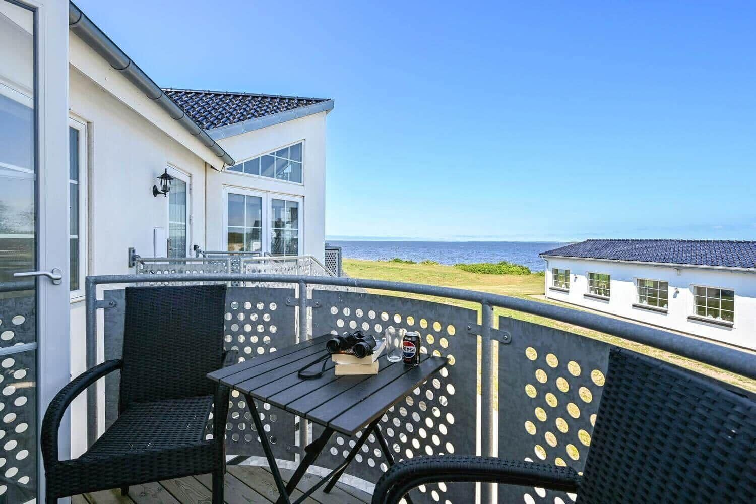 Een balkon met een tafel, stoelen en een camera.
