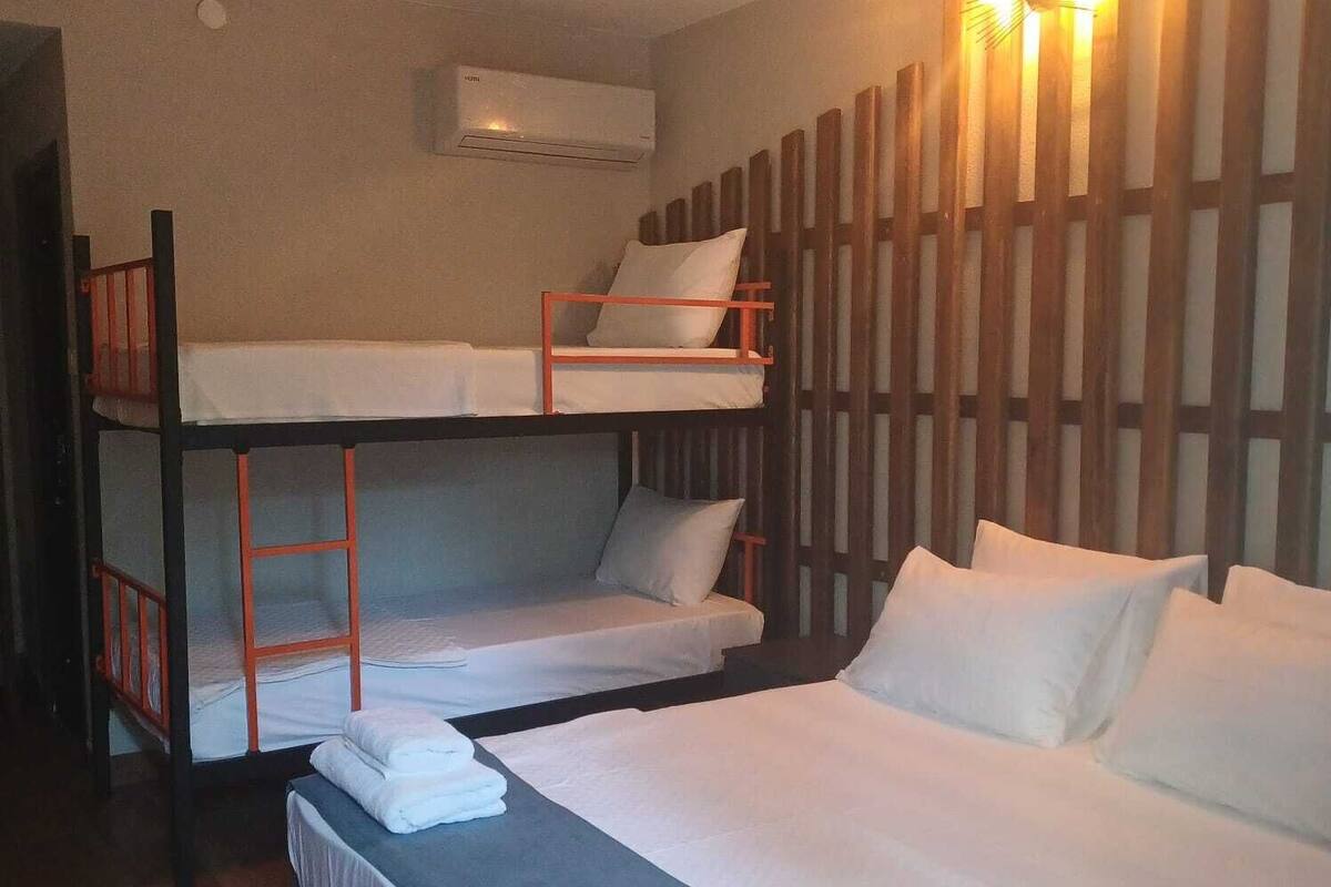 Ein Schlafzimmer mit Etagenbetten, einem Schreibtisch und einem Bett.