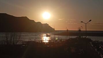 A sunset over a body of water with a pier and boats.