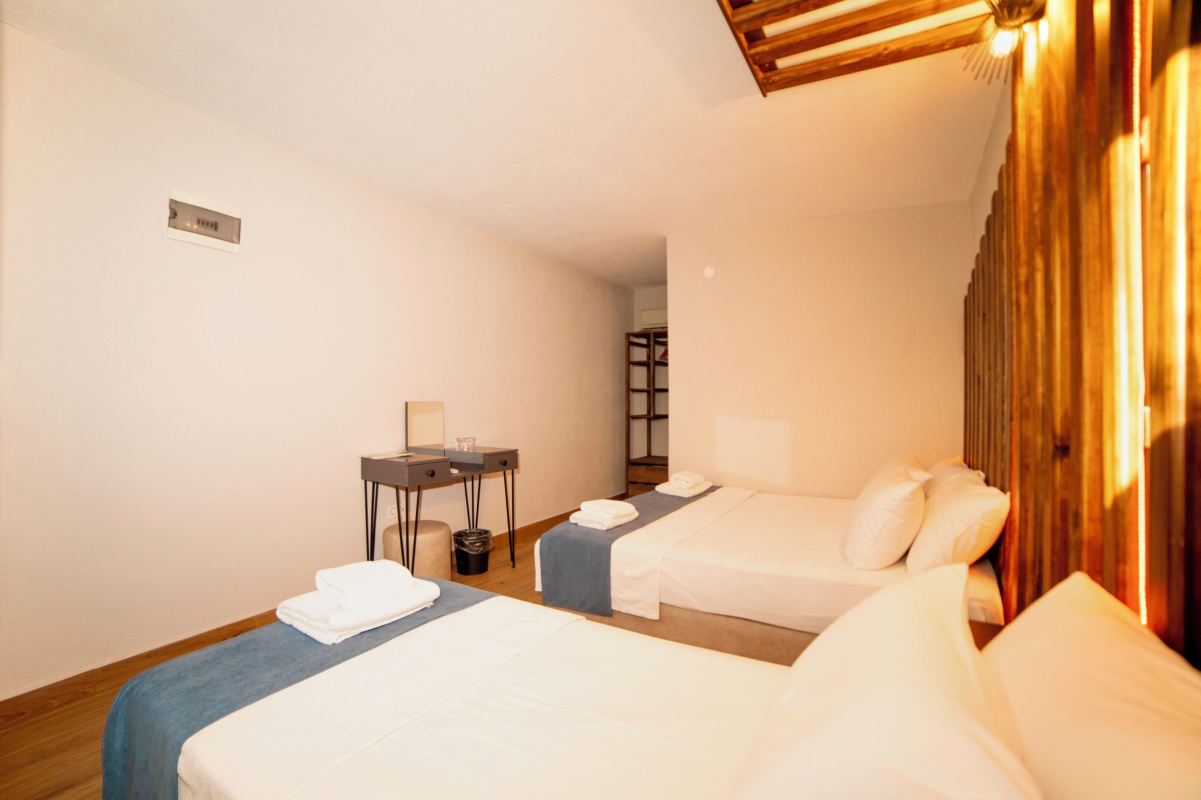 Une chambre d’hôtel avec deux lits, un bureau et une chaise.