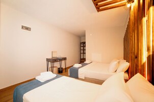 Habitación de hotel con dos camas, un escritorio y una silla.