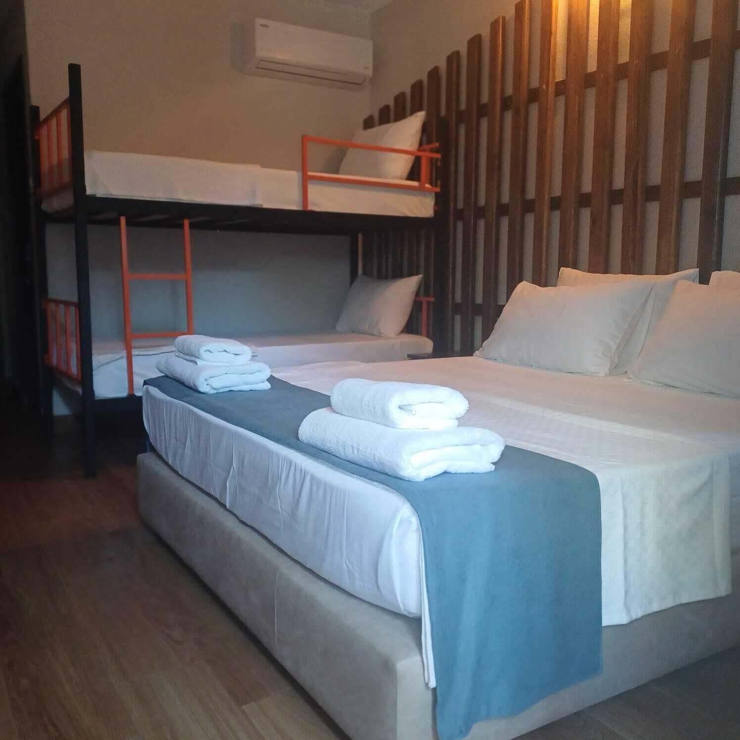 A dormitory room with bunk beds, a sofa, and a bed.