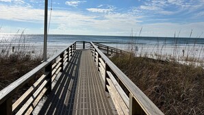 A wooden boardwalk leading to the beach with a clear sky and ocean in the background. - Crystal Tower 1606 by Liquid Life (Gulf Shores)