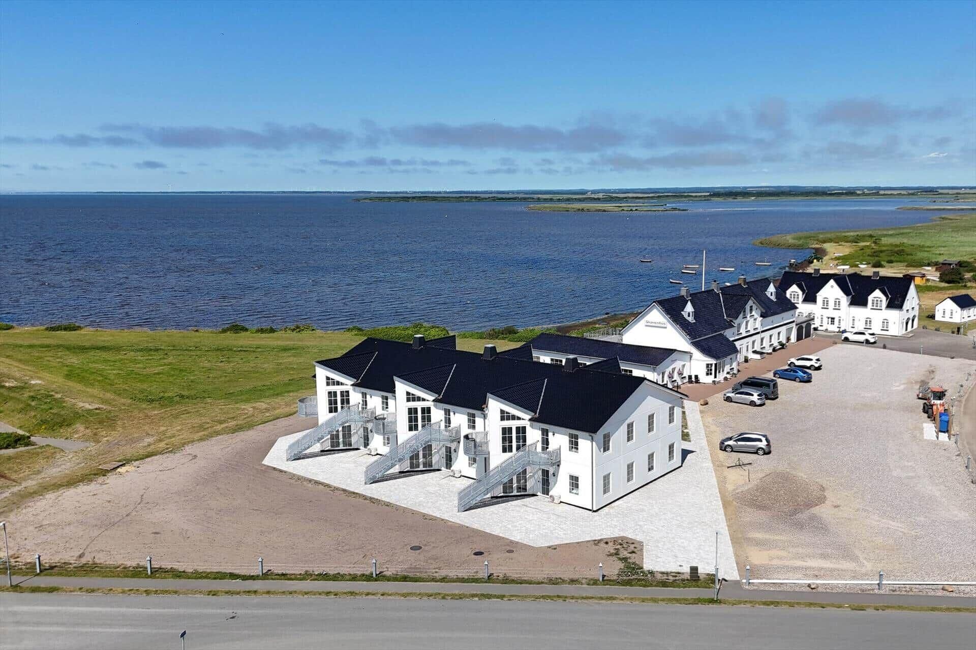 Ein Hotel an der Küste mit Parkplatz und Meerblick.