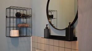 A bathroom with a towel rack, a toilet paper roll, a hairdryer, a soap dispenser, and a mirror. - Double room in the Gasthaus am Finowkanal (former school from 1875). (Wandlitz)