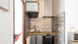 A compact kitchen with a built-in oven, a sink, and a microwave. - Downtown Apartment ° 2 bedrooms ° near the Arènes ° air conditioning  (Nîmes)