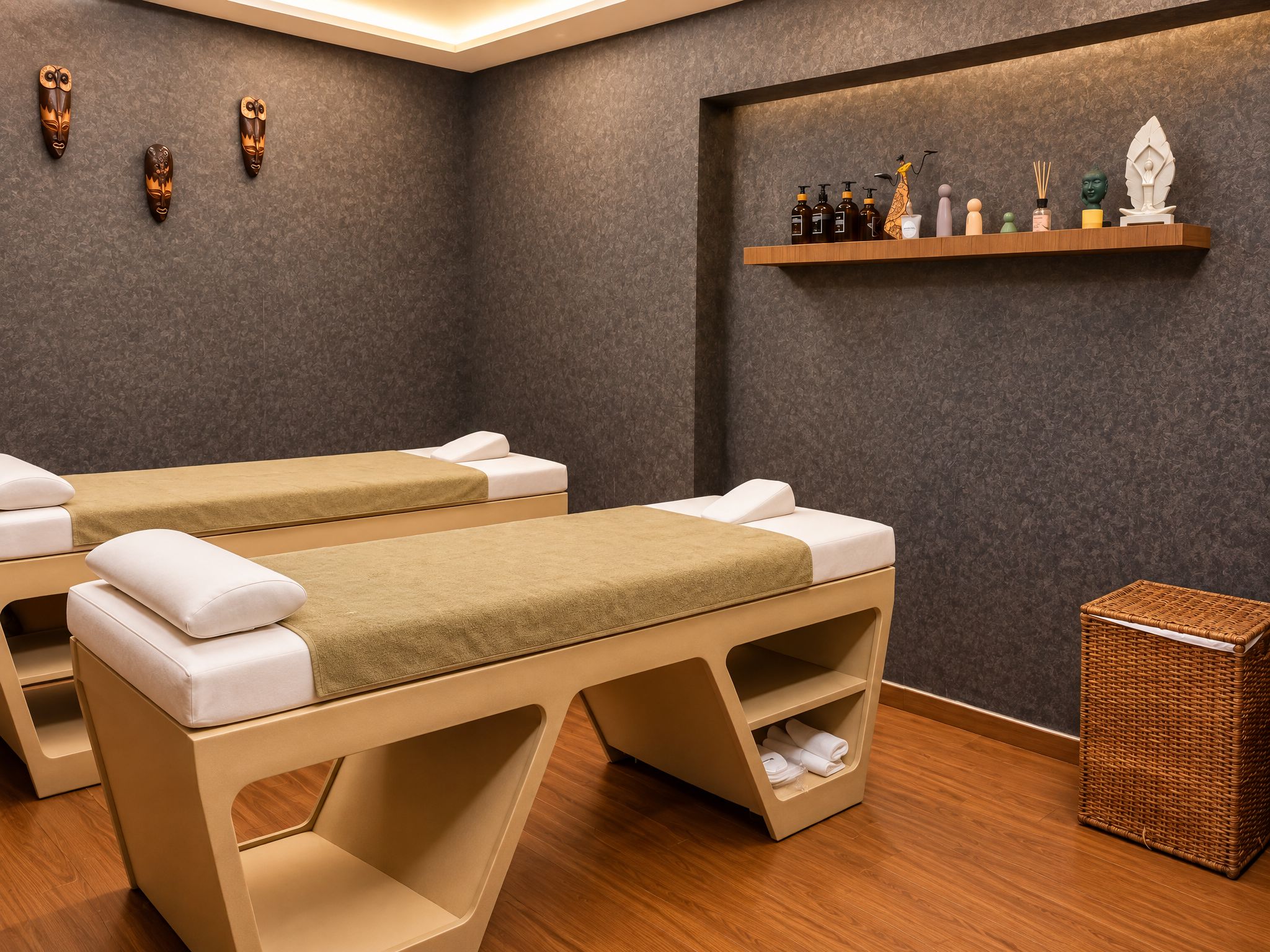 Un cuarto de spa con dos camillas de masaje, un estante con artículos de aseo personal y una cesta de mimbre.