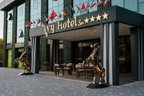 The Ivy Hotels facade with a modern design, including a prominent entrance and two horse statues. - ivy Hotel Spa (Cinarcik)