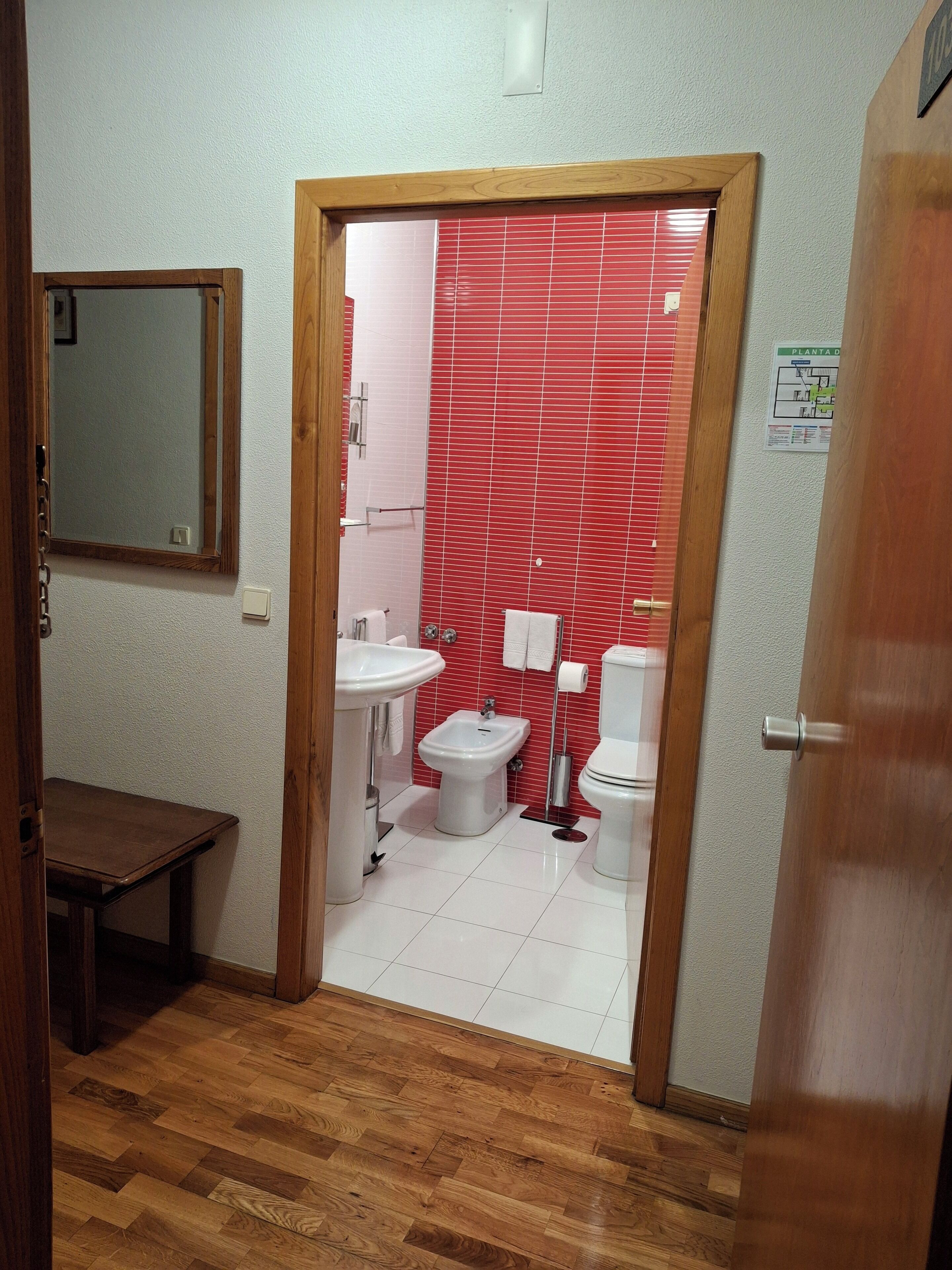 Ein Badezimmer mit Holzboden, Waschbecken, Bidet und Toilette.