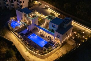 Un hotel moderno con piscina, zona de estar al aire libre y un patio bien iluminado.