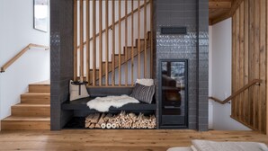 A modern staircase with wooden railings and a built-in bench with a fur throw.