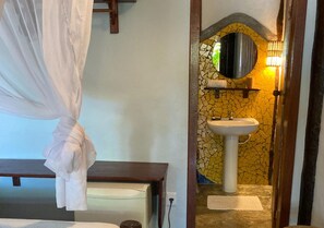 A bedroom with a bed, a bedside table, and a canopy. - Pousada Shangri-lá (Itacaré)