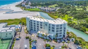 A multi-story hotel with a flat roof, located near a beach and a river. - Cozy Beach living with Breathtaking Ocean and Marsh Views, Sleep 4 (Myrtle Beach)