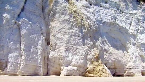 Un acantilado costero con una playa al frente.