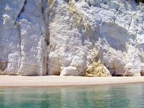 A coastal cliff with a beach in the foreground. - Alba Living Boutique Hotel (Rodi Garganico)