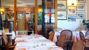 Un restaurante con mesas dispuestas para comer, cuadros en la pared y un interior de madera.