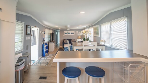 A modern kitchen with a central island, bar stools, and a dining area. - 2 BR@Peachtree, Walk2Sand + Sit by Water (Ocean City)