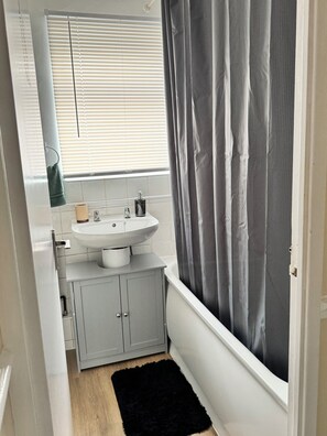 Bathroom features a sink, mirror, and cabinet.