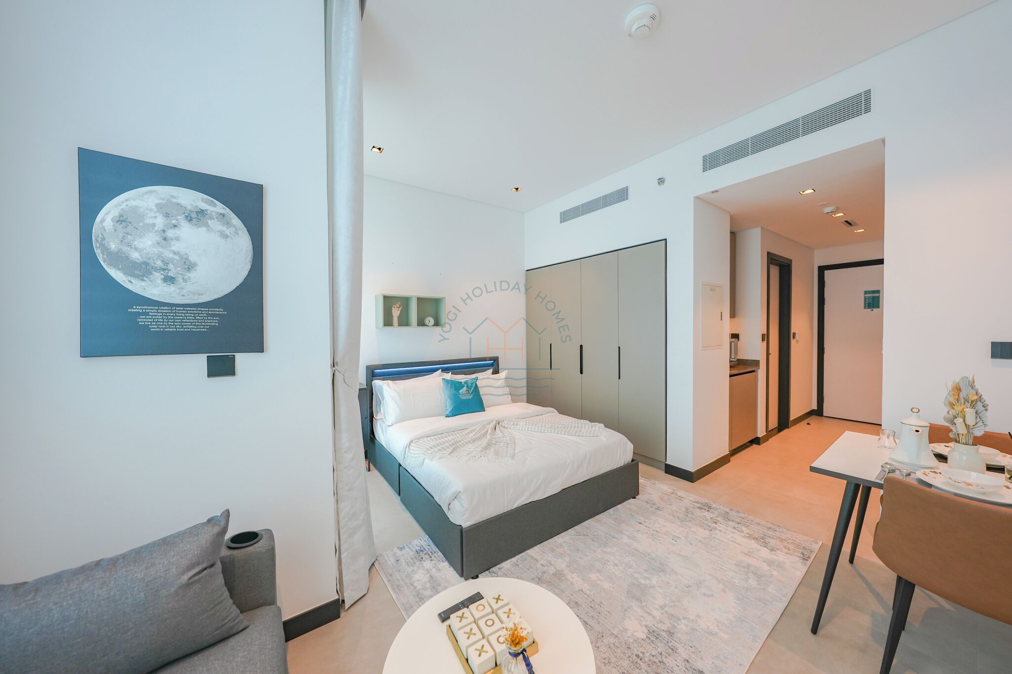 Une chambre d’hôtel moderne équipée d’un lit, d’un canapé, d’une table à manger et d’un coin cuisine.