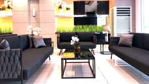 Un lobby moderno con dos sofás, una mesa de centro y una pantalla de televisión.
