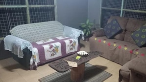 A living room with a patterned sofa, a coffee table, and a potted plant. - Room-outback Retreathotel, Ba Fiji (Ba)