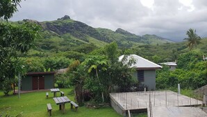A lush green landscape with a small building, picnic tables, and a concrete area, likely a garden or outdoor space. - Room-outback Retreathotel, Ba Fiji (Ba)