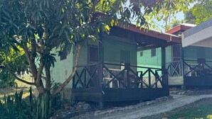 A building with a green exterior, a covered porch with a railing, and a tree in front. - Room-outback Retreat Hotel, Ba Fiji (Ba)