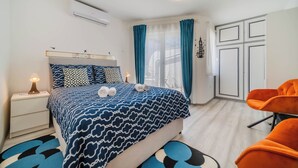 A modern bedroom with a bed, nightstand, and two chairs. - Rooftop Terrace Apartment in Zagreb Lower Town (Zagreb)