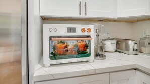 Uma cozinha com forno embutido, torradeira e cafeteira.