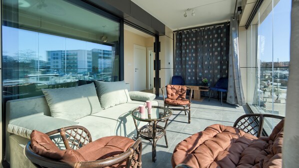 A balcony with a sofa, chairs, and a table. - Apartamenty Sun & Snow w obiekcie Baltic Infinity (Miedzyzdroje)