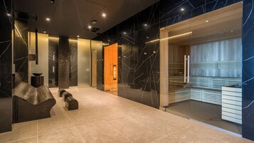 Eine moderne Lobby mit Marmorboden, einer Rezeption und einem Sauna-Bereich.