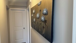 Ein Flur mit einer weißen Tür und einem Wandbild von metallischen Blumen.