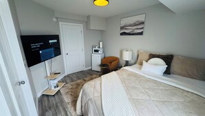 Ein Hotelzimmer mit einem Bett, einem Schreibtisch, einem Fernseher, einer Mikrowelle und einer Tür.