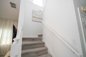 A staircase with white walls and wooden steps. - Gorgeous 4Bd w Pool at Encantada Resort 8523 (Kissimmee)