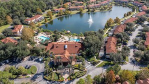 An aerial view of a residential area with a lake, houses, and a swimming pool. - Gorgeous 4Bd w Pool at Encantada Resort 8523 (Kissimmee)