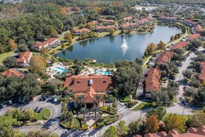 An aerial view of a residential area with a lake, houses, and a swimming pool. - Gorgeous 4Bd w Pool at Encantada Resort 8523 (Kissimmee)