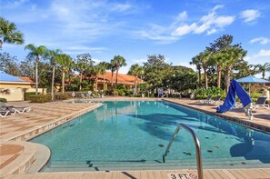 A swimming pool with clear blue water, surrounded by lounge chairs and palm trees. - Gorgeous 4Bd w Pool at Encantada Resort 8523 (Kissimmee)