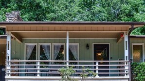 A two-story building with a covered porch and a stone chimney. - 05234 - 34 South Pego Way (Hot Springs)