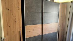 Une pièce dotée d’une porte coulissante composée d’un mélange de panneaux en bois et de panneaux gris foncé.