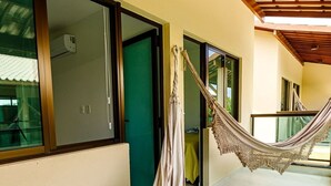 A hammock hanging between two doors in a hallway with a view of a building outside. - Casa BeiraMar 4QTS Piscina-SH031 (Ipojuca)