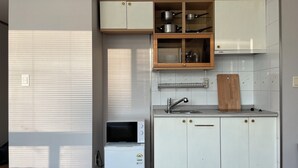 Una cocina compacta con microondas, un fregadero y armarios.